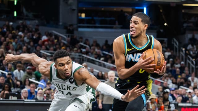 Indiana Pacers guard Tyrese Haliburton (0) dribbles the ball while Milwaukee Bucks forward Giannis Antetokounmpo (34) 